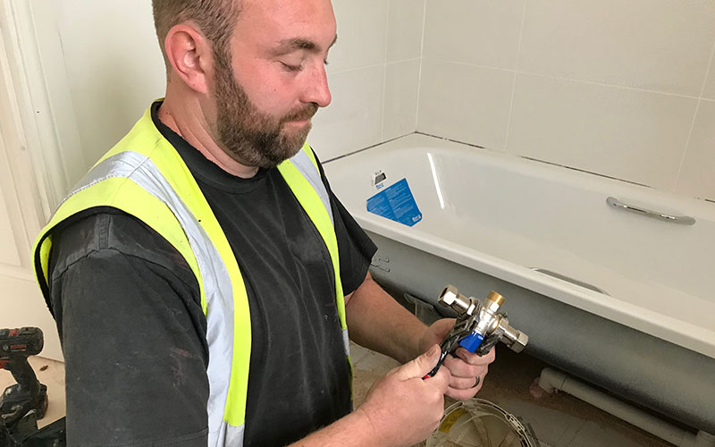 Plumber installing Thermostatic Mixing Valve