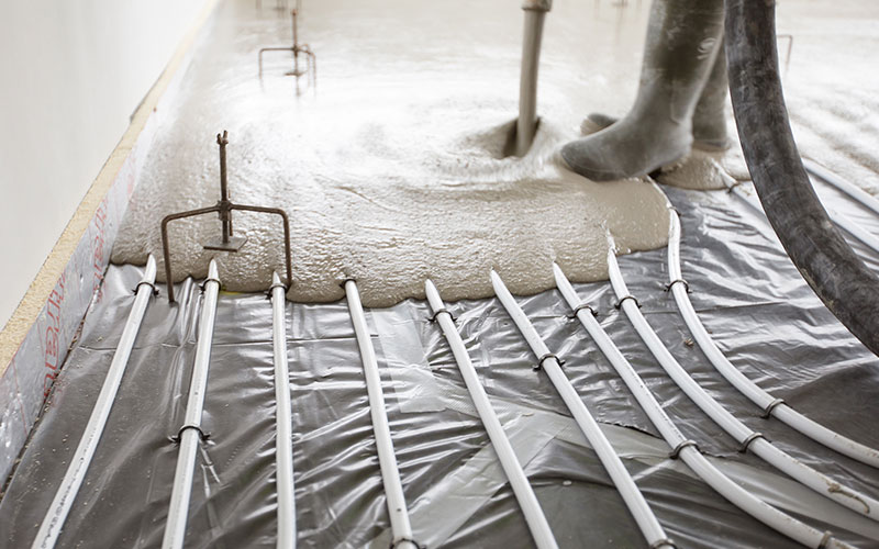 Man pouring screed on a underfloor heating installation