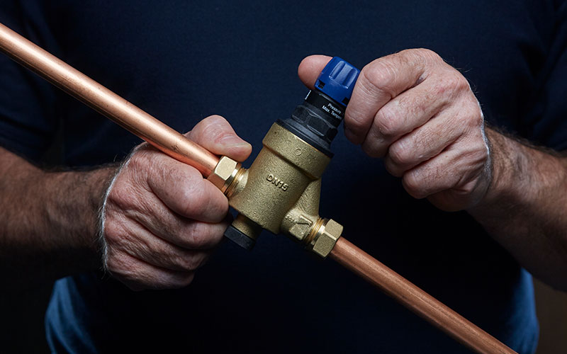 PRV held by a plumber with copper pipe connections